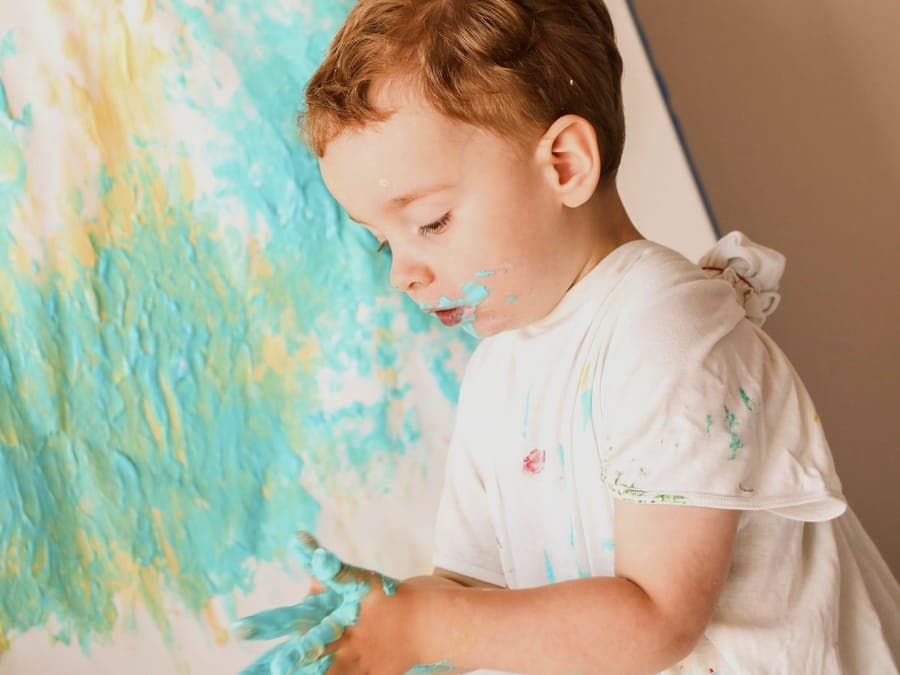 FitScouts Kindergarten: Kind malt vertieft an der Wand