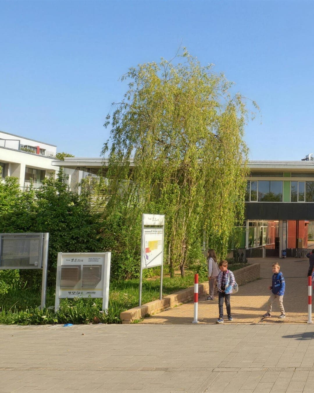Schulkinder sitzen gemeinsam draußen im Hof