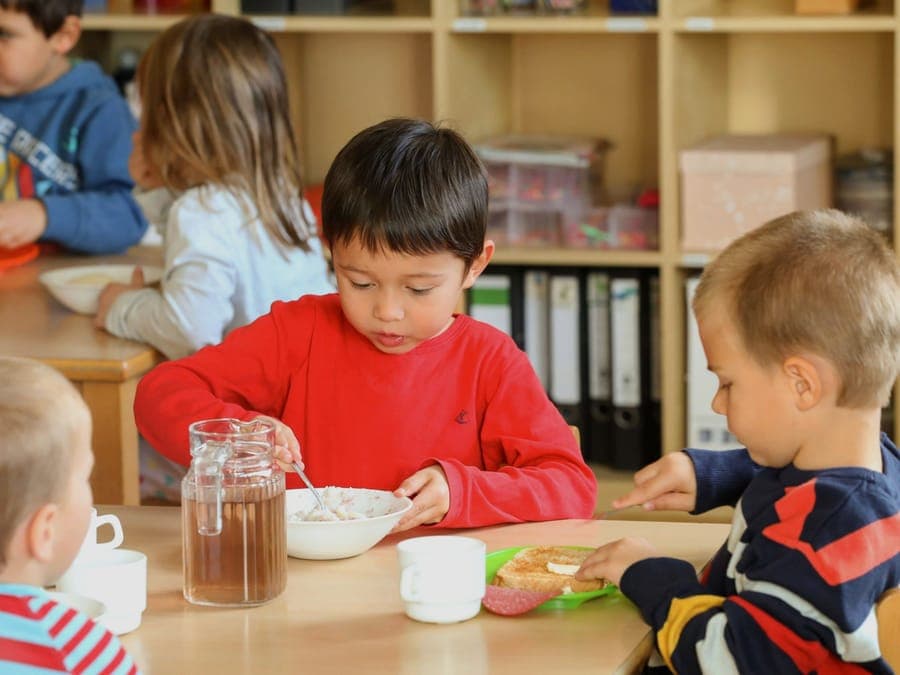 FitScouts Kindergarten Wiesbaden: Kinder rühren am Frühstückstisch eifrig selbst mit