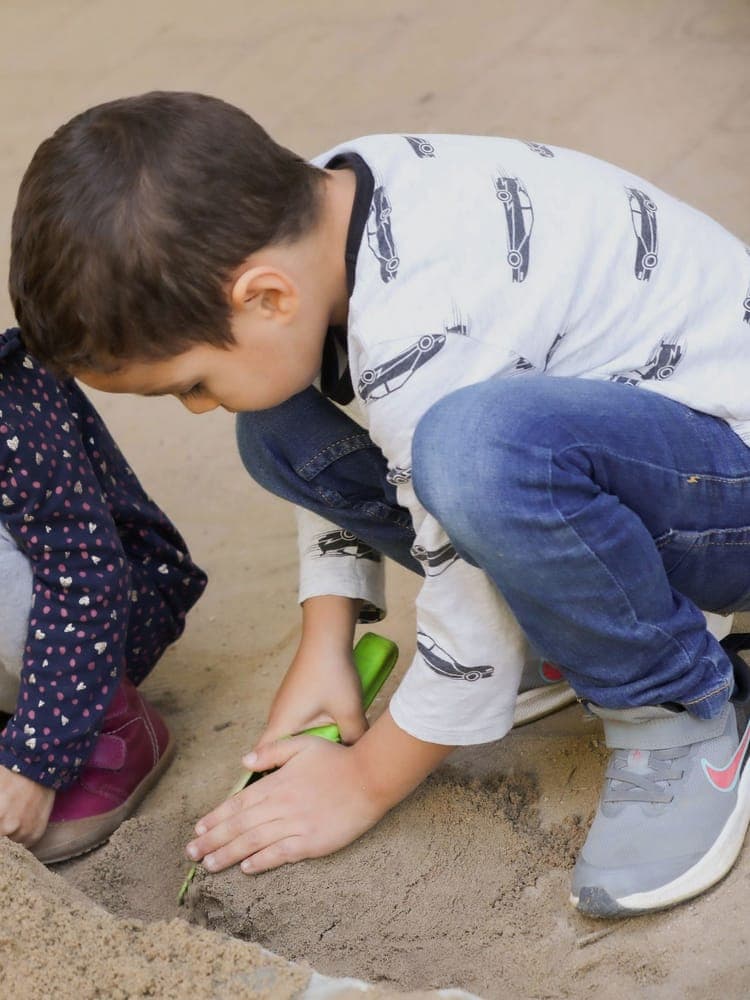 FitScouts Kindergarten Wiesbaden: zwei Kinder spielen konzentriert im Sandkasten
