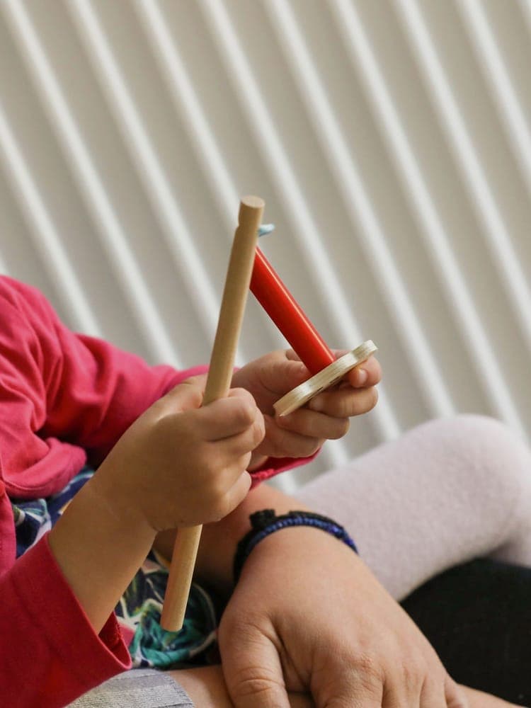 FitKids Kinderkrippe Wiesbaden: Kleinkind spielt vertieft mit Holzspielzeug