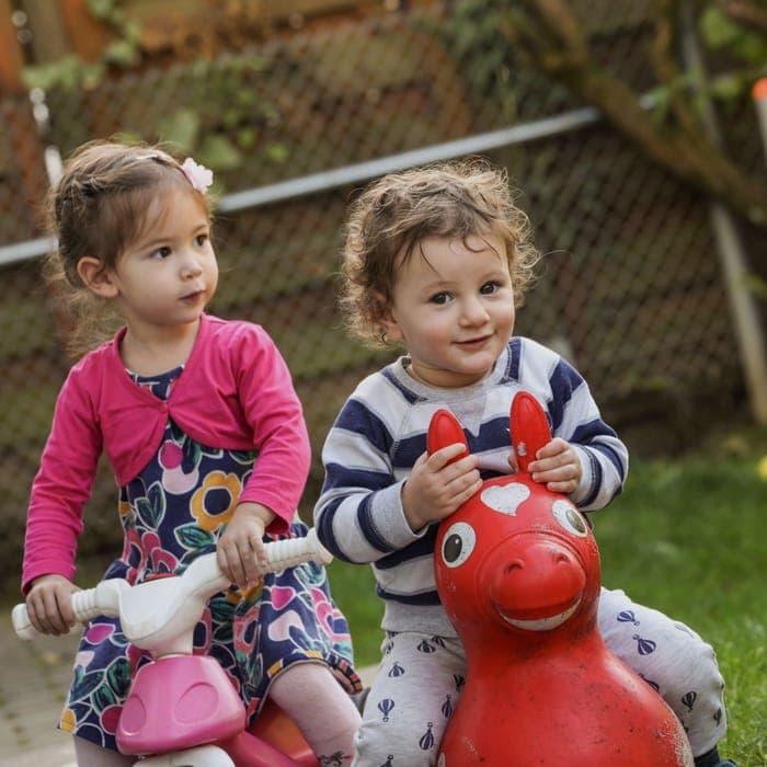 Zwei lachende Kleinkinder im Garten der FFF-Kita Wiesbaden