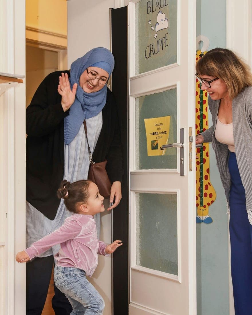 Erzieherin begleitet ein Kleinkind liebevoll während der Eingewöhnung