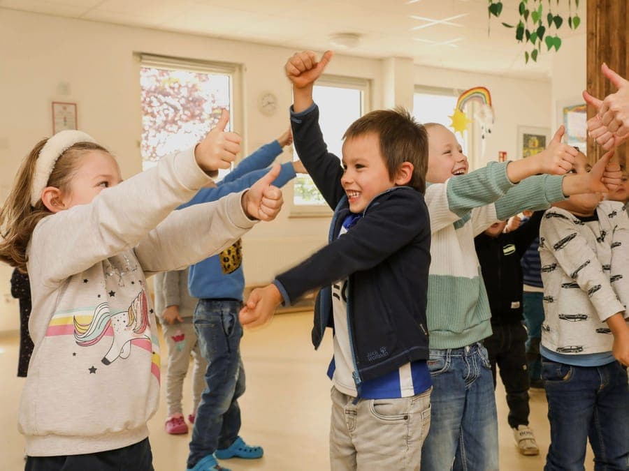 Schulkinder strecken begeistert die Daumen nach oben